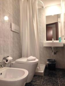 a bathroom with a white toilet and a sink at HOTEL MILAZZO in Rome