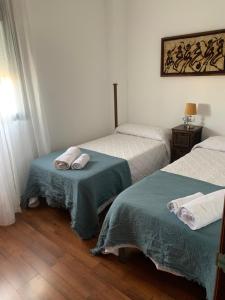 a bedroom with two beds with towels on them at Ría de Huelva in Huelva