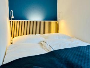 Bett mit weißer Bettwäsche und Kissen in einem Zimmer in der Unterkunft AyCatcherHomes Top Lage charmante Atmosphäre in ruhiger Altstadt Marburgs Apartment Sirius in Marburg an der Lahn