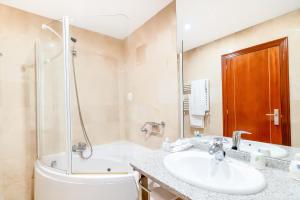 a bathroom with a sink and a shower and a tub at Ponferrada Plaza in Ponferrada