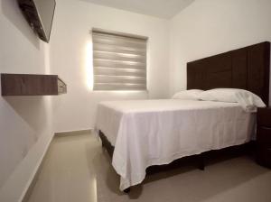 蒙特雷的住宿－Casa Pardo，卧室配有白色的床和窗户。