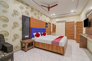 a hotel room with a bed and a tv at OYO Flagship Hotel Aditya Grand Inn in Guntūr