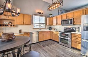 a kitchen with wooden cabinets and a wooden table at Welcoming West Fargo Retreat w Backyard in West Fargo