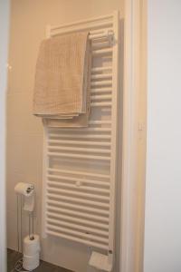 a bathroom with a towel hanging on a door at Le Marais - Appart'Escale in Saint-Nazaire