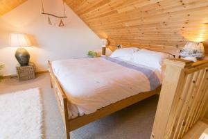 a bedroom with a bed with a wooden ceiling at Pen y Graig in Rhoscolyn