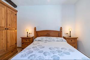 a bedroom with a bed and two dressers and two lamps at Molino del Nacimiento in Laujar de Andarax