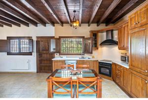 a kitchen with wooden cabinets and a table and chairs at Molino del Nacimiento in Laujar de Andarax