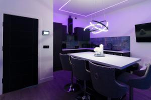 a kitchen with purple lighting and a table and chairs at Hamilton Apartments in Leeds