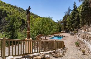 a resort with a swimming pool and a wooden fence at Molino del Nacimiento in Laujar de Andarax