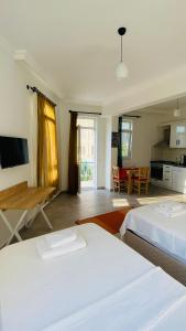 a bedroom with two beds and a kitchen and a table at Kaş Centre -The Rush Apart-1 in Kas