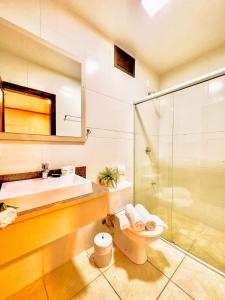 uma casa de banho com um lavatório, um WC e um chuveiro em Luzzy Hotel em Canela