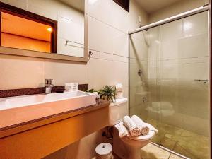 y baño con lavabo, aseo y ducha. en Luzzy Hotel en Canela