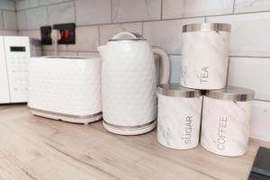a group of four coffee mugs sitting on a kitchen counter at The Oasis Apartment in Leeds