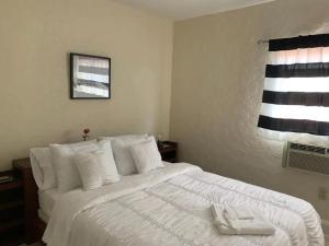 a bedroom with a large white bed with white pillows at Private Rooms close to Miami Airport - Free parking - 02 in Miami