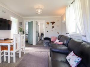 a living room with a black leather couch and a table at Resthaven in Harwich