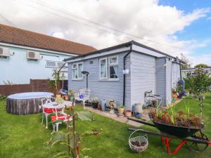 a tiny house in a yard with a wheelbarrow at Resthaven in Harwich