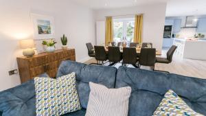 a living room with a blue couch and a table at Sirusa in Trearddur