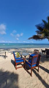 duas cadeiras e uma mesa na praia em Crystal beach apartment em Mombasa