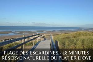 a boardwalk to the beach with the words place des acadiens minutes preserve at GOOD HOME Chez Lulu, plage & centrale in Gravelines