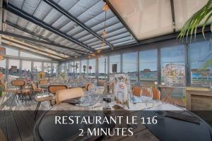 a restaurant lvl with tables and chairs and windows at GOOD HOME Chez Lulu, plage & centrale in Gravelines