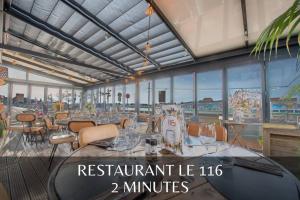 un restaurante lvl con mesas, sillas y ventanas en GOOD HOME Chez Lulu, plage & centrale, en Gravelines