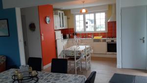 a kitchen with a table and a kitchen with red walls at maison de l ile in Damgan