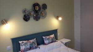 a bedroom with a bed with two clocks on the wall at maison de l ile in Damgan