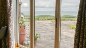 an open door with a view of the ocean at Y Beudy in Llanrhwydrys