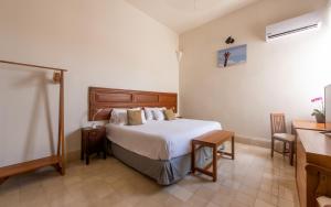 Schlafzimmer mit einem Bett, einem Tisch und einem Waschbecken in der Unterkunft Villa Orquídea Boutique Hotel in Mérida
