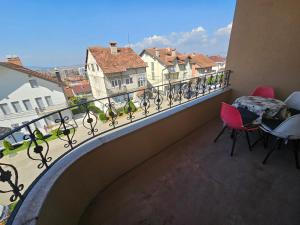 a balcony with chairs and a table and a view of a city at Dardania-Home in Prizren