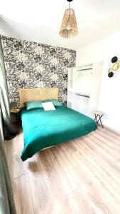 um quarto com uma cama verde e uma parede em L'échappée MERs- Maison 3 chambres au Centre 500m de la plage em Mers-les-Bains