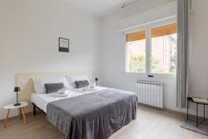 a white bedroom with a bed and a window at Bologna Suite in Bologna