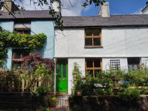 a white house with a green door at Cuddfan in Llanberis