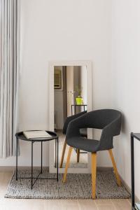 波隆那的住宿－博洛尼亞套房公寓，镜子前的椅子和桌子