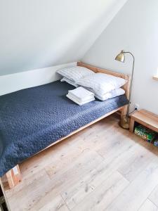 sypialnia z łóżkiem z niebieską pościelą i lampką w obiekcie Domek letniskowy Wigsun w mieście Leszczewek