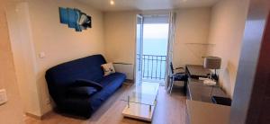 Una sala de estar con un sofá azul y una mesa de cristal. en Bellerive, pieds dans l'eau lac & montagnes, en Publier