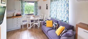 a living room with a purple couch and a table at Domek letniskowy Wigsun in Leszczewek