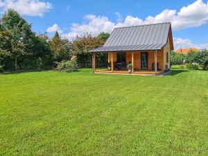 mały drewniany dom na trawniku w obiekcie Domek letniskowy Wigsun w mieście Leszczewek