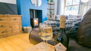 a bottle of wine and a glass on a table at Cuddfan in Llanberis