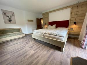 a bedroom with a large bed and wooden floors at Ferienwohnung Lisal in Mutters