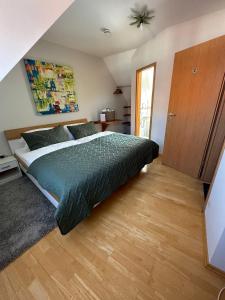 1 dormitorio con 1 cama con edredón verde en Vinopresso GmbH - Café Römer, en Prichsenstadt