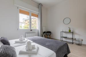 a white bedroom with a bed and a window at Bologna Suite in Bologna