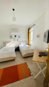 a room with three beds and a desk and a laptop at Kaş Centre -The Rush Apart-1 in Kas