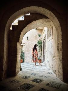a woman walking through an archway in a building at Elsa d'Ortigia in Siracusa