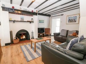 a living room with a couch and a fireplace at Tyddyn Serri in Rhosneigr
