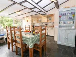 a kitchen with a table and chairs and a kitchen with blue cabinets at Tyddyn Serri in Rhosneigr