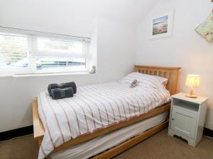 a small bedroom with a bed and a window at Tyddyn Serri in Rhosneigr