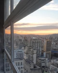 - une vue sur la ville au coucher du soleil depuis la fenêtre dans l'établissement Apto Varandas no andar 38 ,abaixo do SampaSKY, à São Paulo