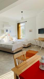 a bedroom with two beds and a chair and a table at Kaş Centre -The Rush Apart-1 in Kas