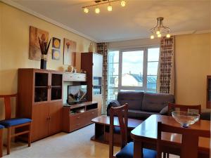 a living room with a couch and a table at Apartamentos SOL Y PLAYA Foz in Foz